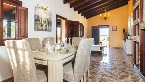 A dining area with a wooden table set for four, surrounded by wicker chairs. - Finca Can Pep (Sant Joan)
