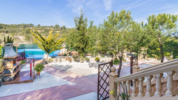 A landscaped outdoor area with a pool, potted plants, and a staircase leading to a balcony. - Finca Can Pep (Sant Joan)