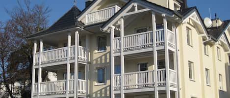 Un edificio de varios pisos con balcones y techo plano.