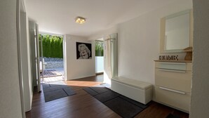Een moderne badkamer met een badkuip, een spiegel en een wastafelmeubel met een 'HOME' bordje.