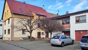 A residential street with houses, a tree, and parked cars. - 125m² Hohberg near Black Forest, Strasbourg, Europapark, Offenburg, Baden-Baden (Hohberg)