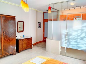 A modern bathroom with a wooden vanity, a mirror, and a glass shower enclosure.