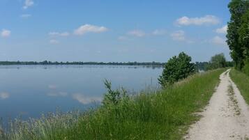 A calm lake with a dirt path along the edge.