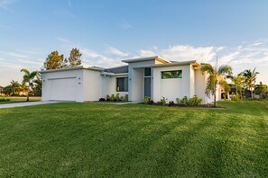 A modern two-story house with a garage, a covered patio, and a well-maintained lawn. - VILLA AVIVA - modern, boat-lift, large south-facing terrace with spa/pool (Cape Coral)