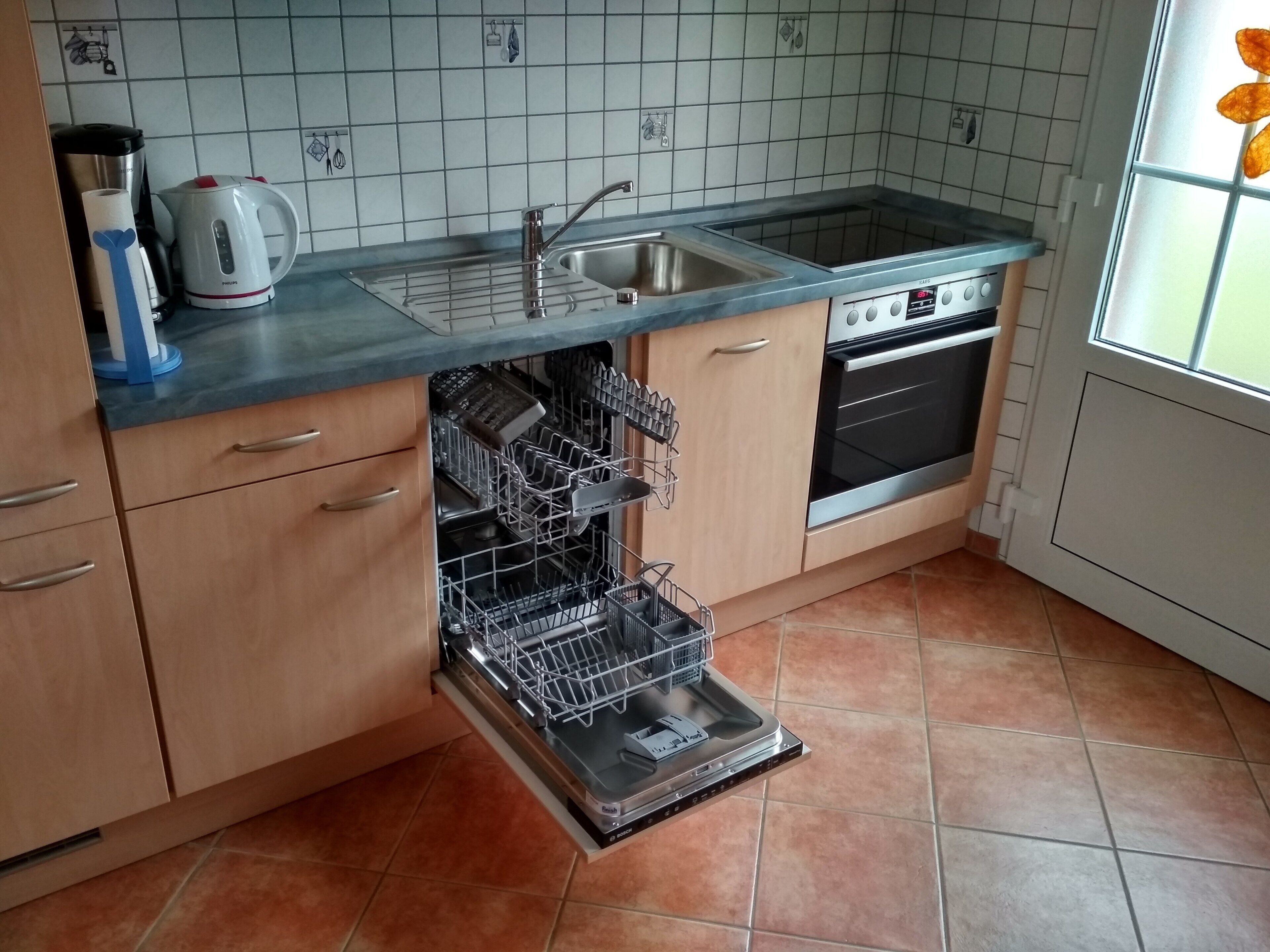 Une cuisine équipée d’un lave-vaisselle, d’un four et d’une machine à café.