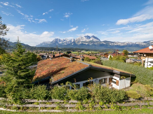 Ein Wohngebiet mit Häusern, einem Bergmassiv im Hintergrund und einem klaren Himmel.