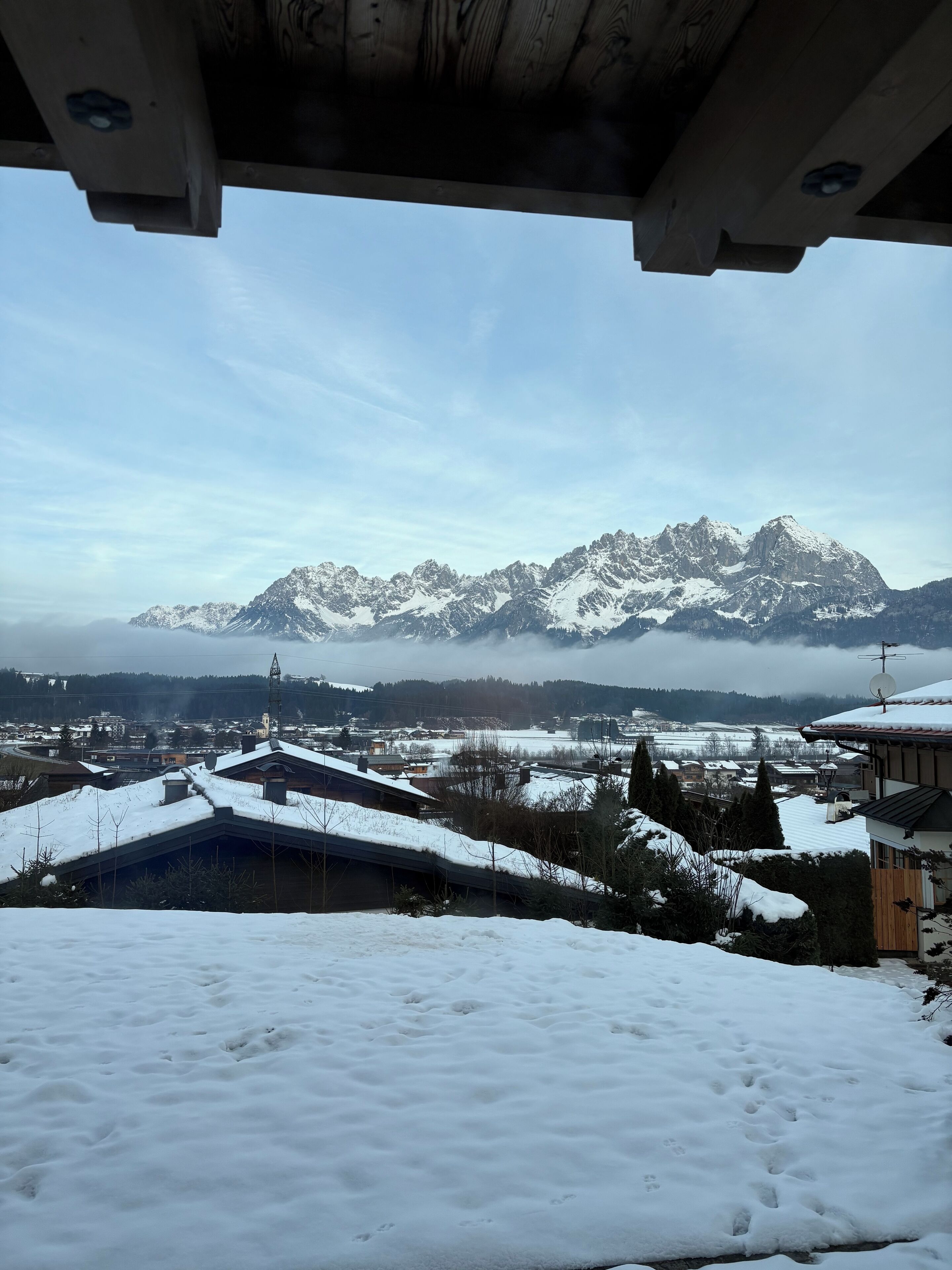 A snowy mountain landscape with a town in the foreground.