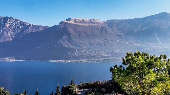 Un paisaje montañoso con una vista despejada de un lago y un pequeño asentamiento a lo lejos.