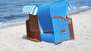 Quiosco en la playa con toldo a rayas y un letrero con el número 29.
