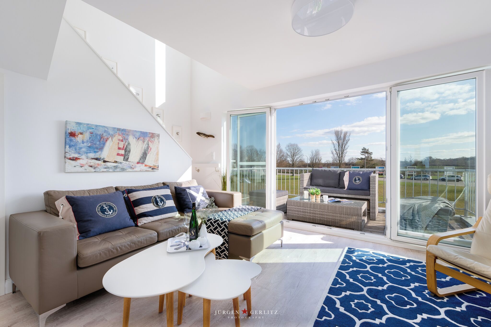 Un salon moderne avec un canapé, une table basse et un tableau accroché au mur.