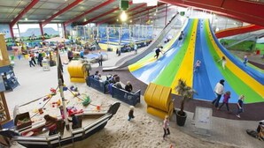 An indoor play area with slides, sand, and play structures.