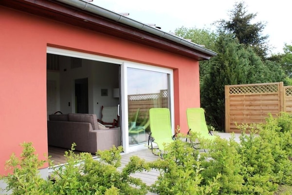 Wohnbereich mit großem Schiebefenster und angrenzender Holzterrasse