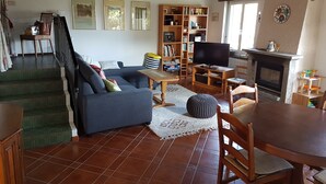 A living room with a sofa, TV, bookshelf, fireplace, and staircase. - Nice Mediterranean holiday home. Ideal for families, athletes etc. Nature lovers (Carona)