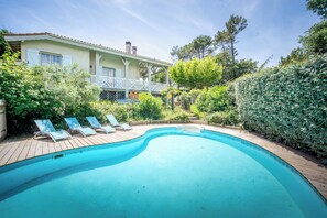 Piscine chauffée, chaises longues
