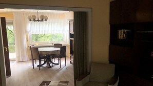 Un coin repas avec une table et des chaises, un canapé et une bibliothèque.