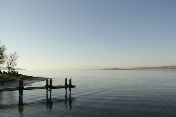 A calm lake with a wooden dock extending into the water. - Spacious, bright vacation apartment "zum Saibling" (Nußdorf)