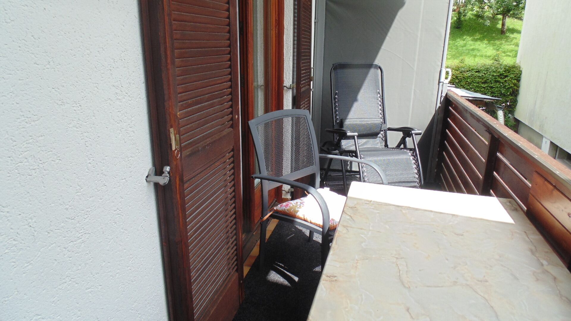 Un pequeño patio al aire libre con una mesa y dos sillas.