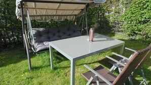 Un área de estar al aire libre con techo, una mesa y sillas.