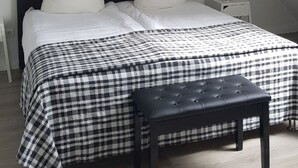 Une chambre à coucher avec un lit, un banc et une table de chevet.