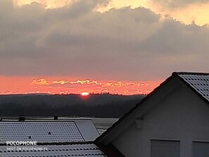 A sunset over a residential area with houses and a clear sky.
