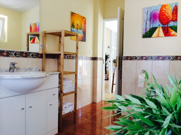 A bathroom with a sink, towel rack, and a door leading to another room.