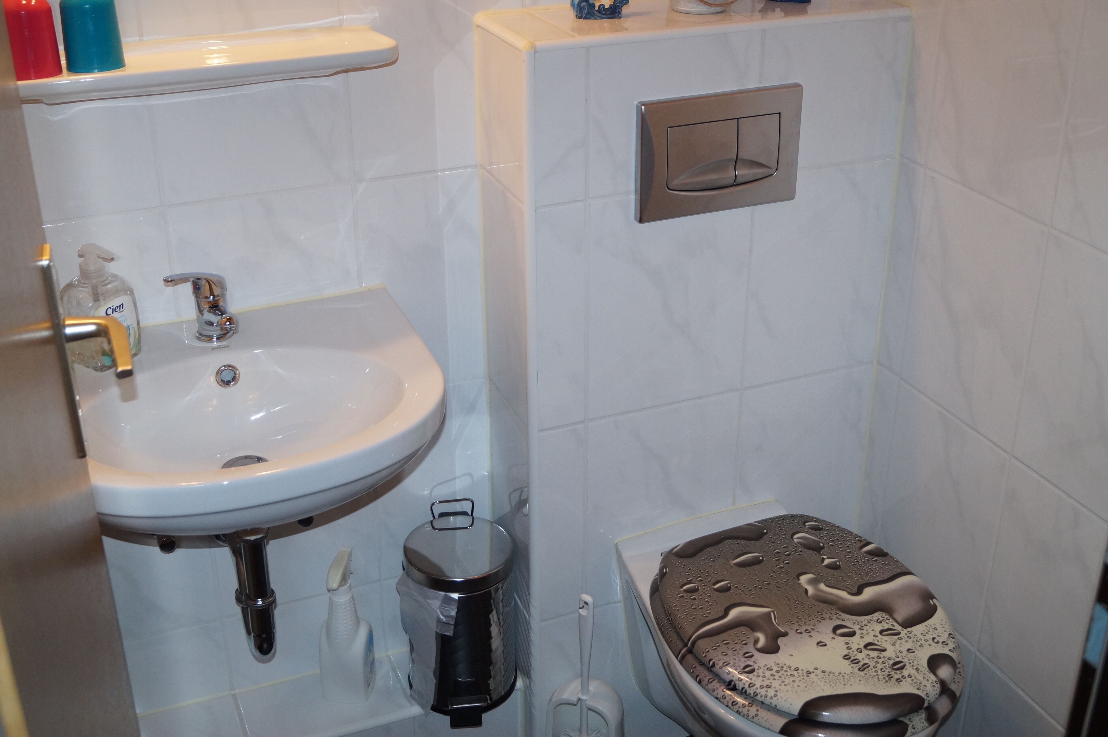 Ein Badezimmer mit Waschbecken, Toilette und Mülleimer.