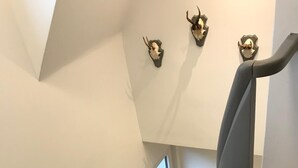 Una escala moderna amb un alfabet negre, una finestra de vidre a la part superior i cranis decoratius a la paret.
