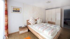 Ein Schlafzimmer mit einem Bett, Nachttischen, einem Kleiderschrank und einem Bild an der Wand.