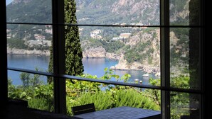 A view from a window overlooking a lake with mountains in the background.