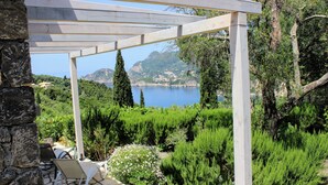 A wooden pergola with a view of a lake and mountains.