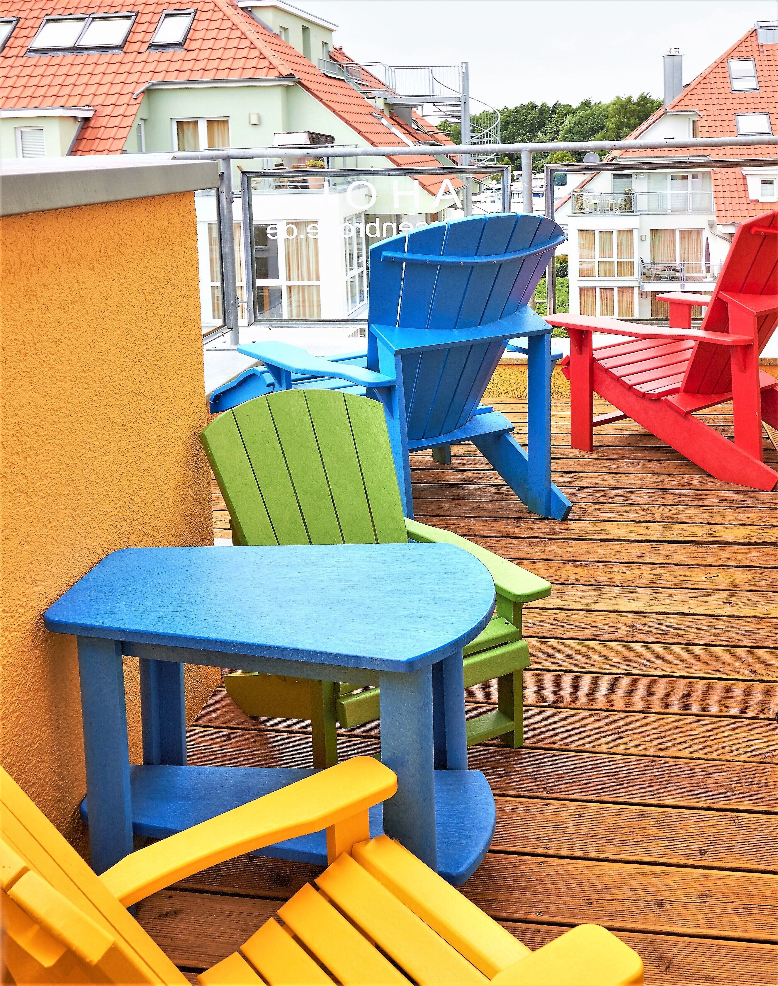 Outdoor seating with colorful Adirondack chairs and a wooden deck.