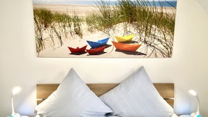 A bed with two pillows and a nightstand with a lamp.