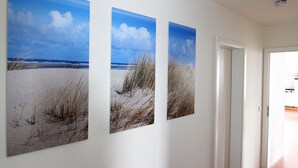 A hallway with three large landscape paintings on the wall.