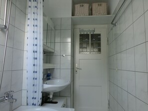 Een bad/douchecombinatie, een haardroger, handdoeken, zeep