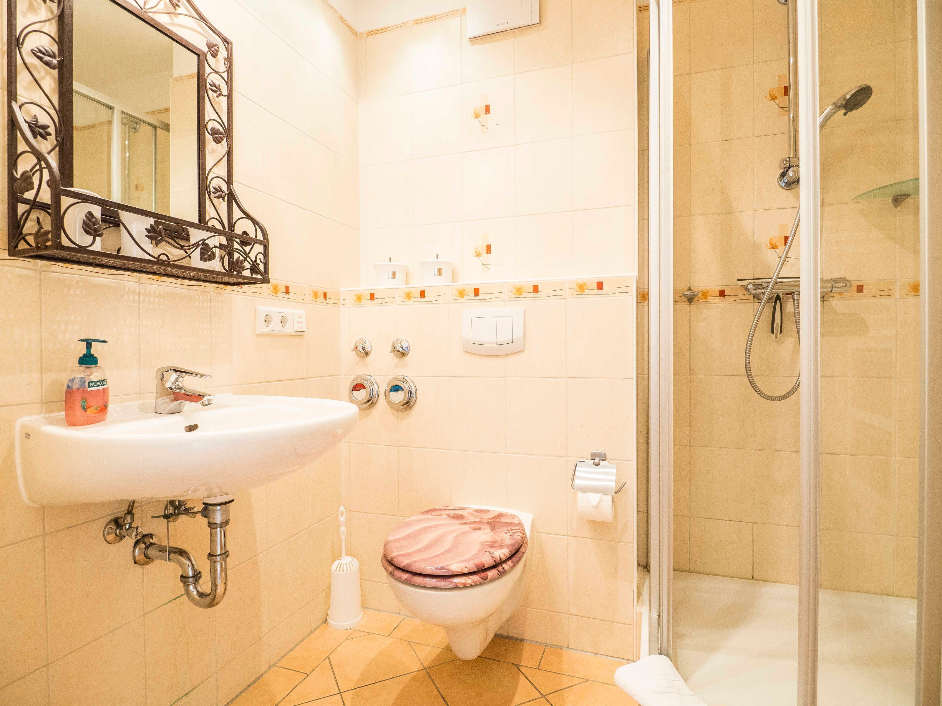 Un bagno con lavandino, wc e doccia.