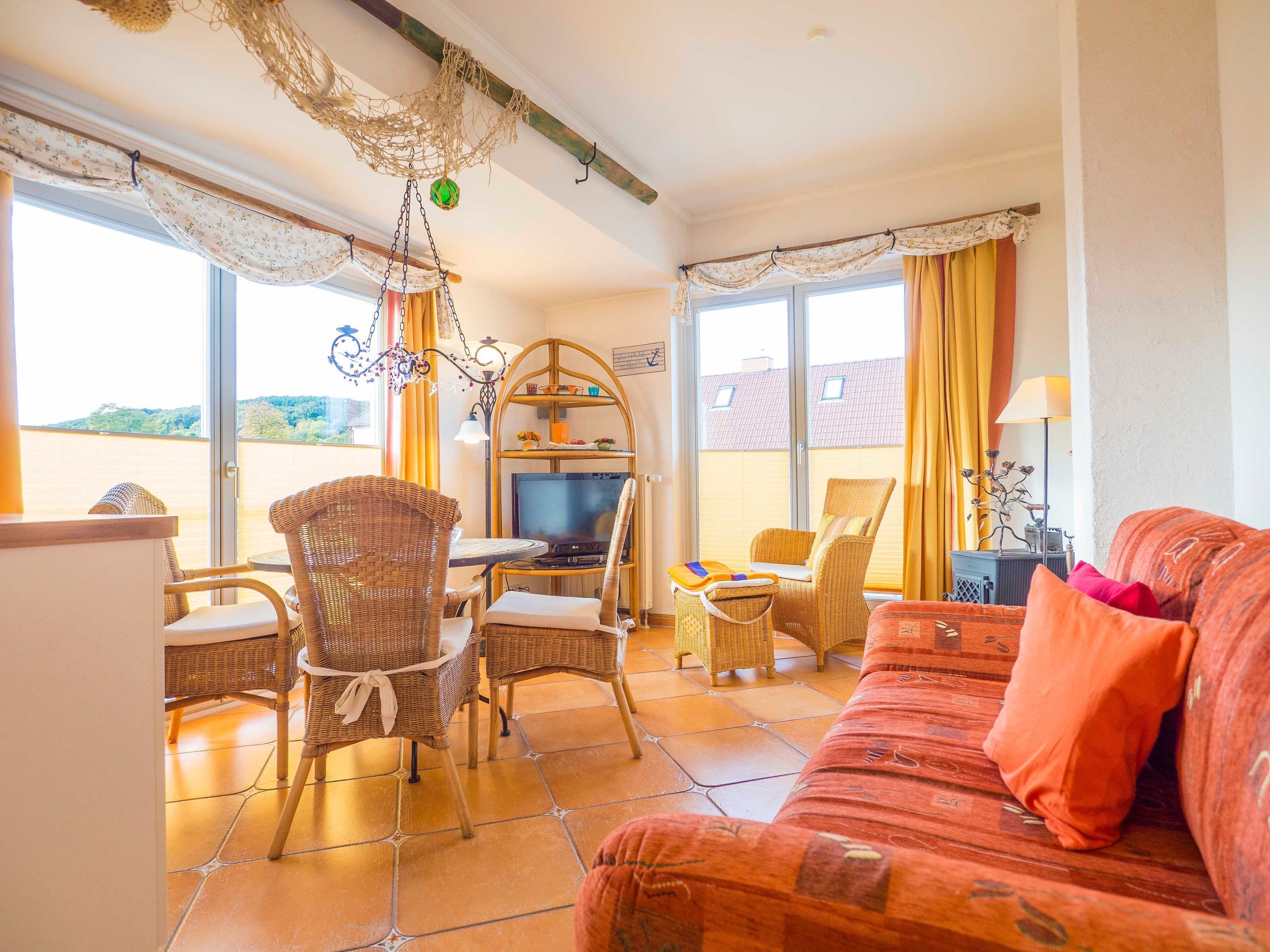 Ein Wohnzimmer mit Rattanmöbeln, einem Fernseher und einer Couch.