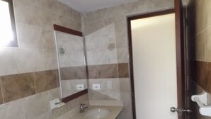 A bathroom with a sink, mirror, and tiled walls. - Hotel La Via (Cartagena)