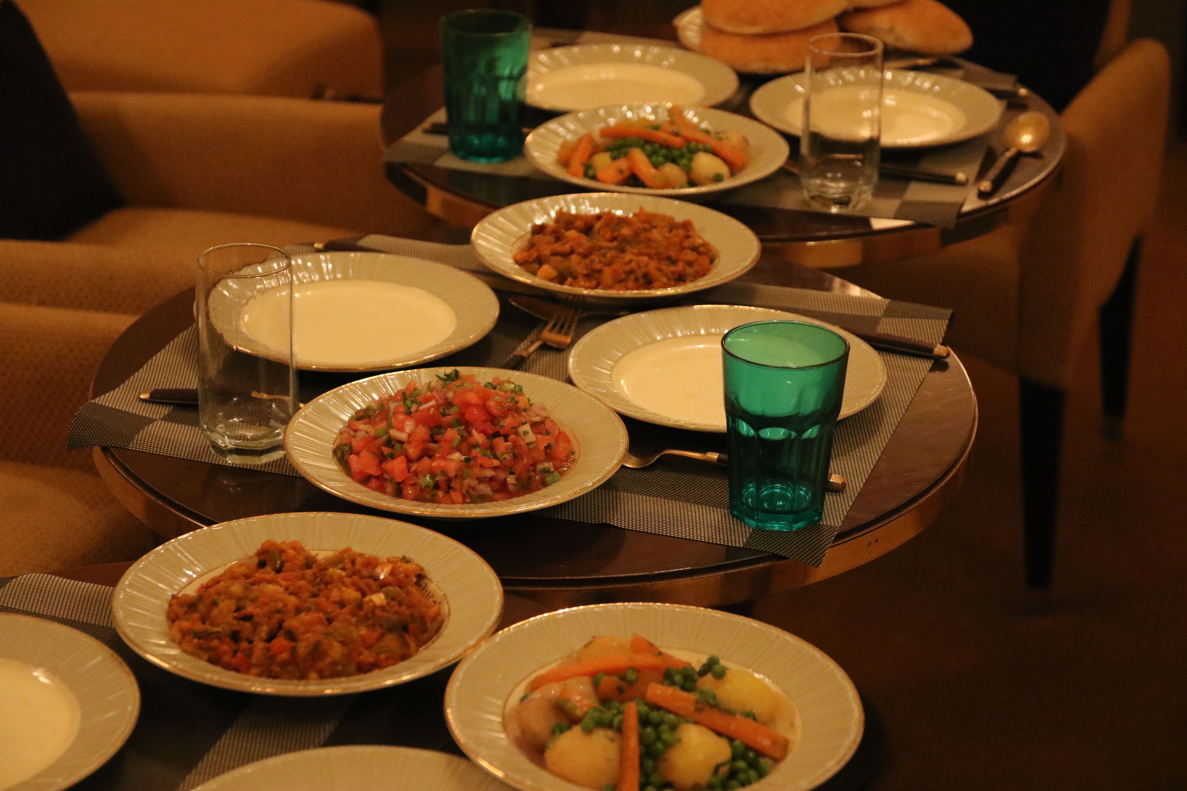 A dining table set with various dishes, glasses, and cutlery.