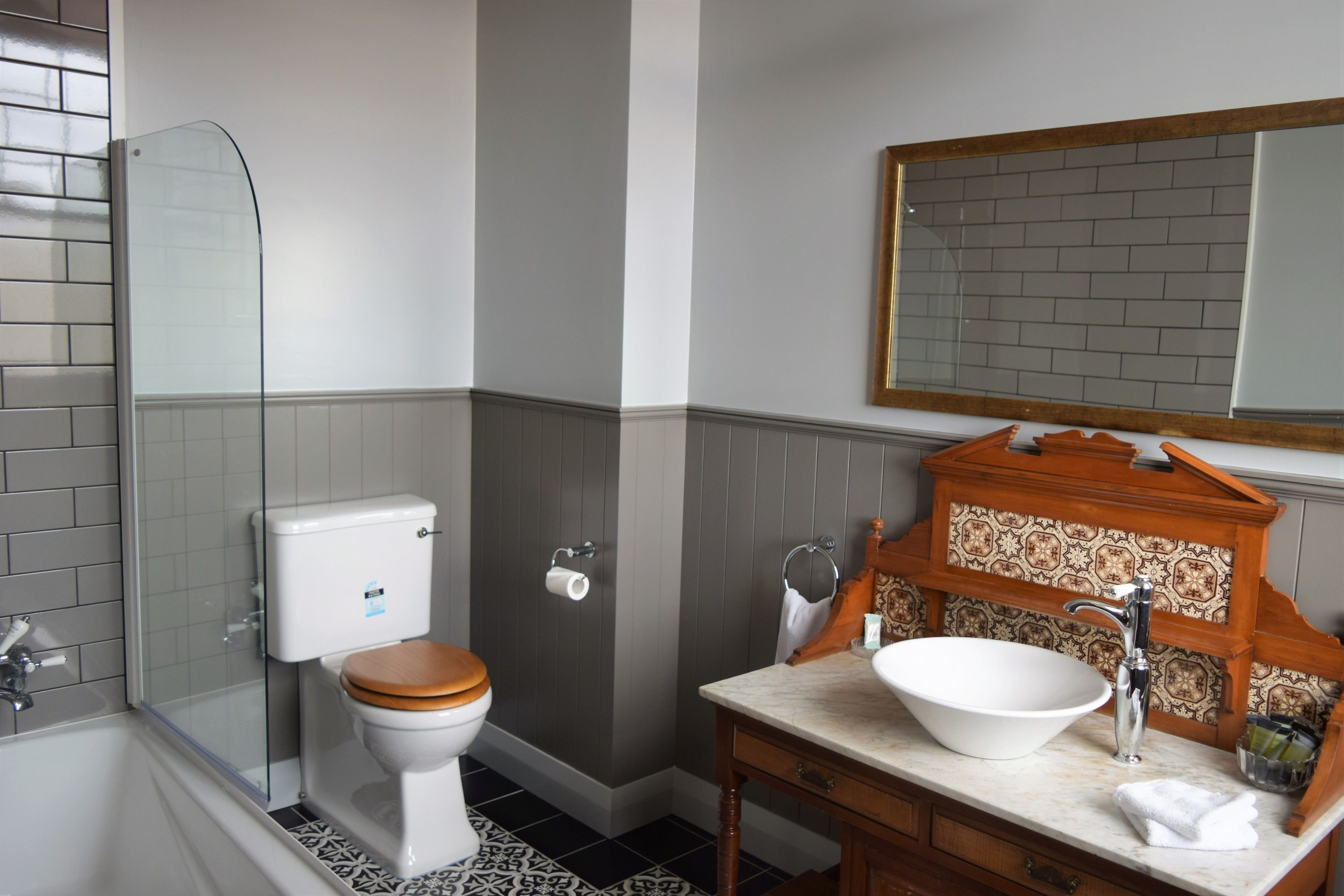 Een badkamer met toilet, wastafel en douche.