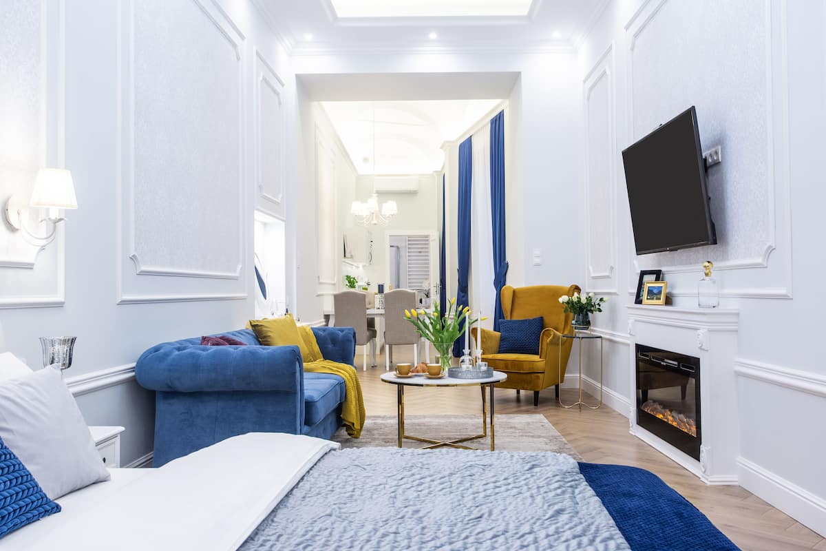 Una sala de estar moderna con sofá, sillón y chimenea.