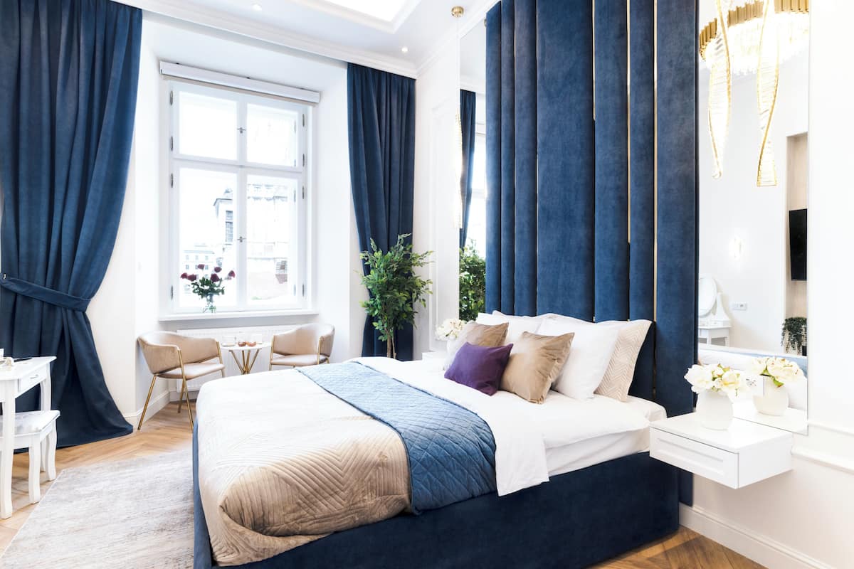 Una habitación de hotel moderna con una cama grande, un escritorio y una ventana con cortinas.