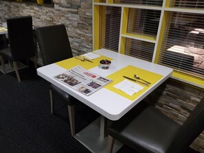A table with a newspaper, cutlery, and a bowl. - Logis La Bonne Auberge (Laval)