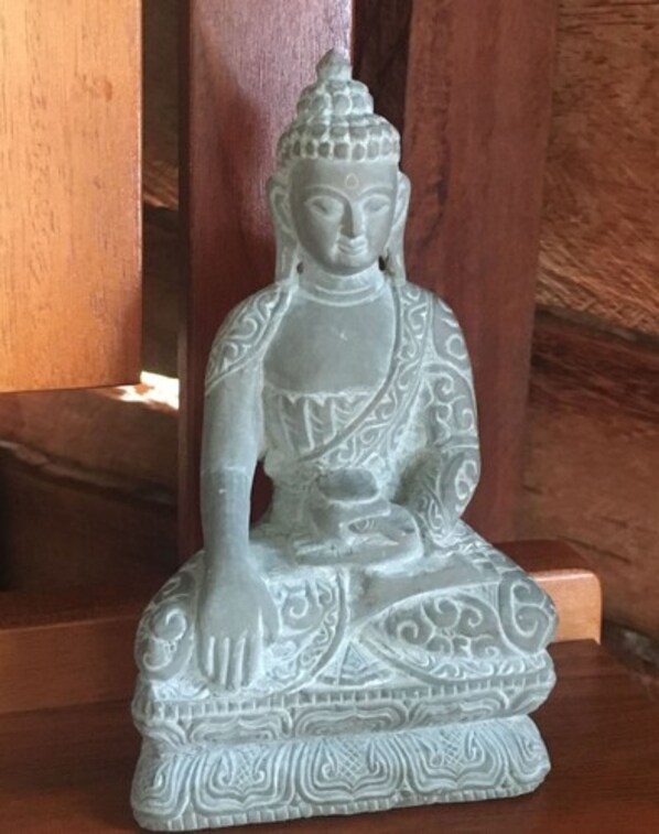 A seated statue with intricate patterns on its base.