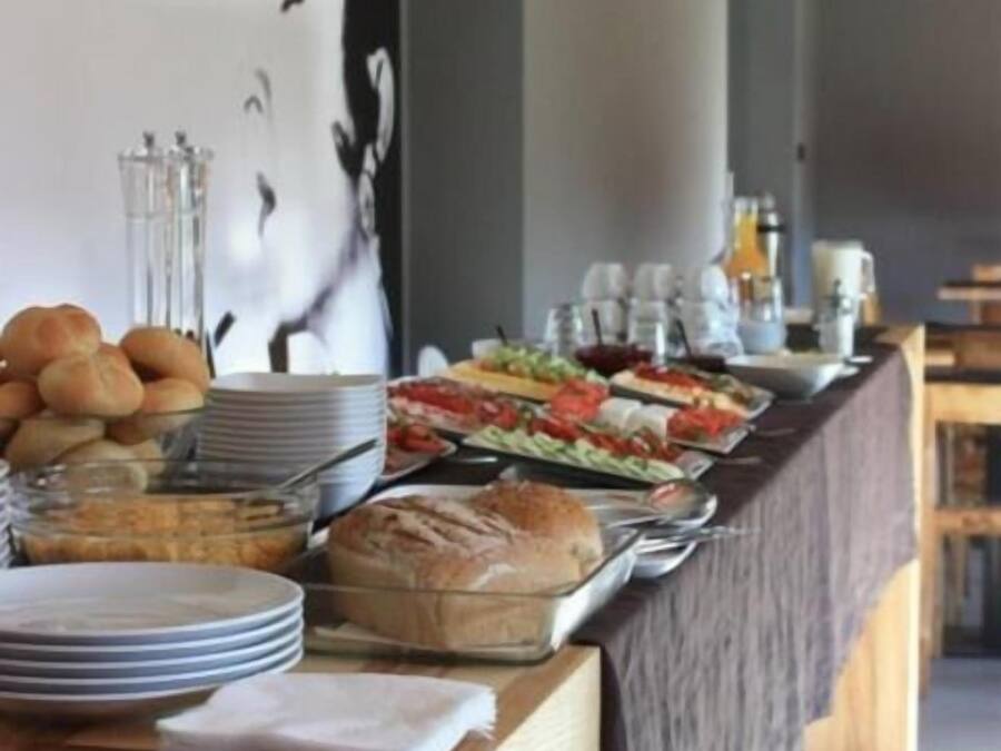 Montaje de bufé con diferentes opciones de comida, incluyendo pan, ensaladas y una estación de bebidas.
