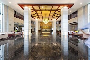 A spacious lobby with a polished marble floor, high ceilings, and a central chandelier. - Li Jing Hotel Mile (Mile)