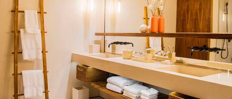 Un baño moderno con una escalera de madera, un espejo grande y un mueble de tocador con cestas de almacenamiento.