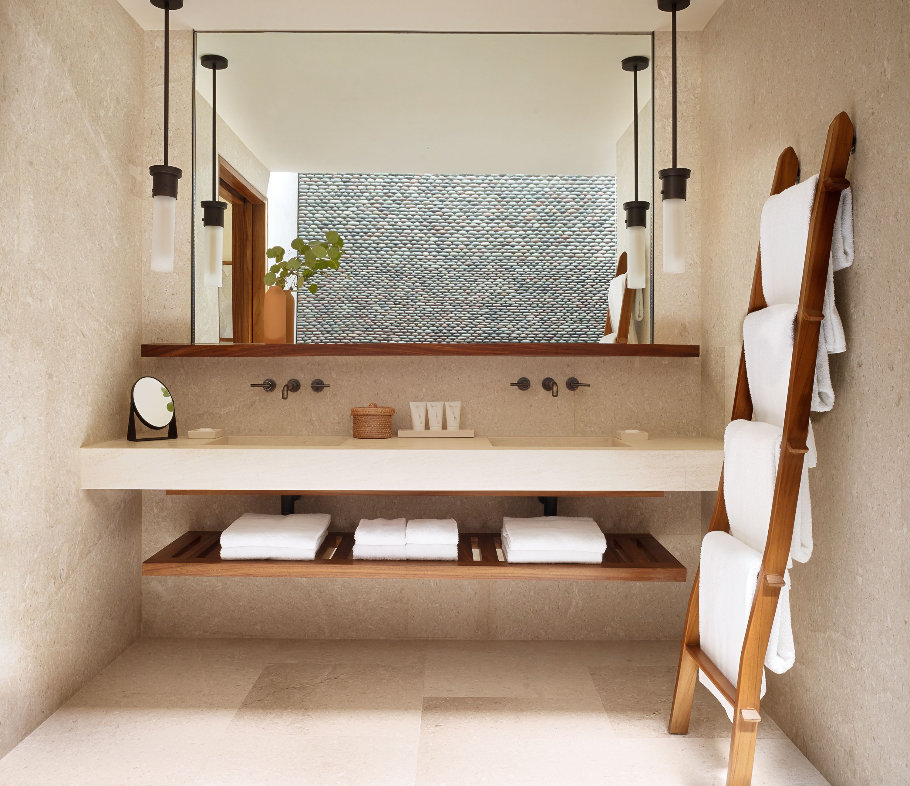 A modern bathroom with a large mirror, wooden shelves, and a towel rack.