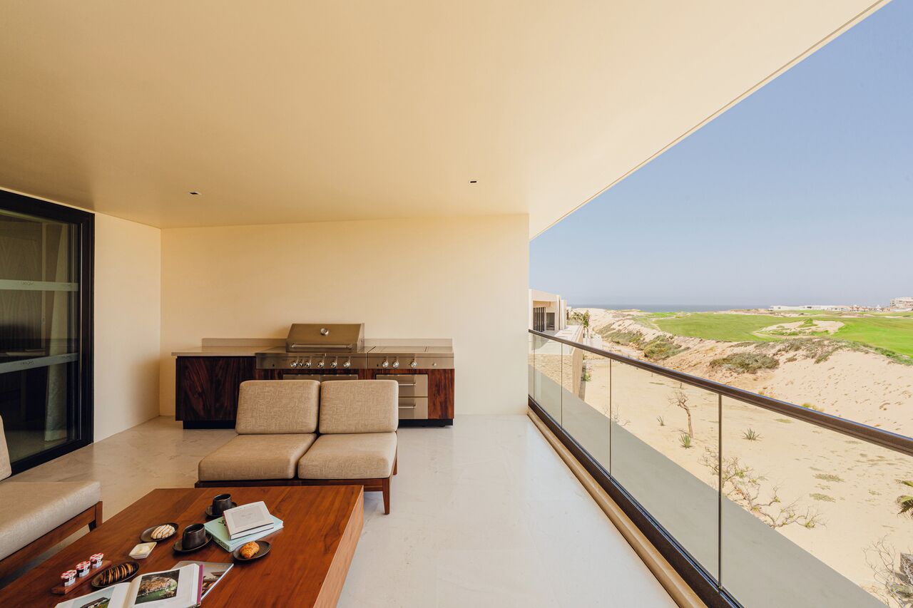 Un salon moderne avec un balcon donnant sur une plage.