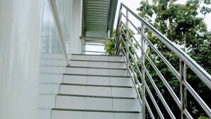 A staircase with metal railings and white steps leading to a covered area.