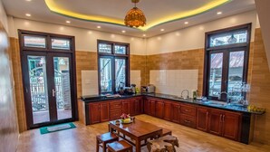 Une cuisine moderne avec des meubles en bois, un îlot central et de grandes fenêtres.